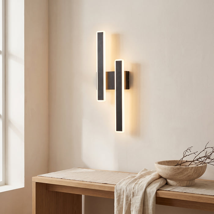 Schwarze LED-Wandleuchte mit zwei versetzten Leuchtstäben in einem hellen Wohnraum
