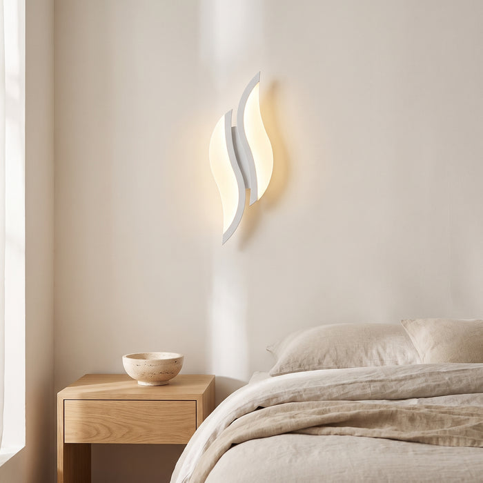 Weiße LED-Wandleuchte mit zwei geschwungenen Acryl-Elementen in einem hellen Wohnraum