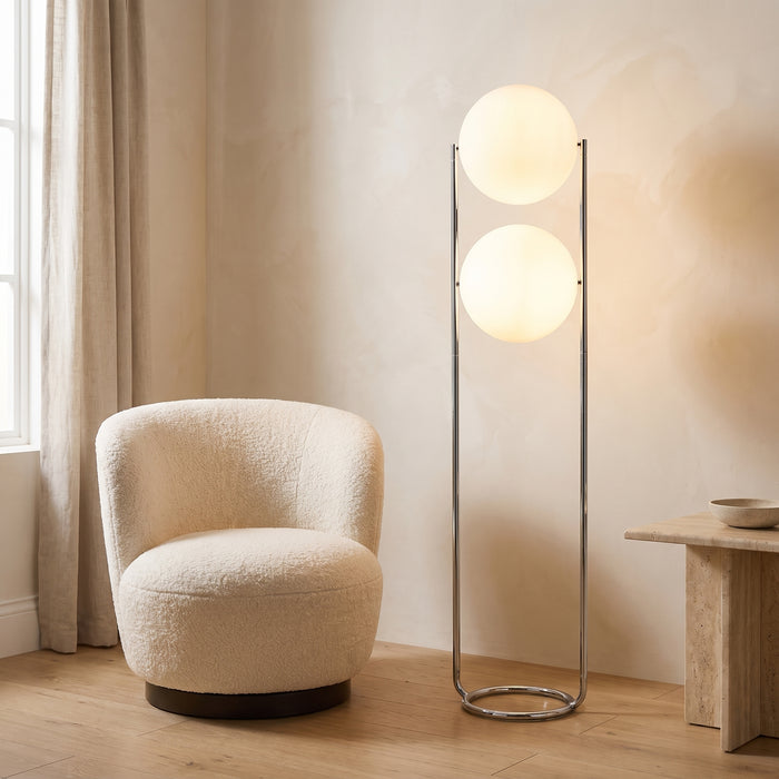 Stehlampe mit zwei weißen Acrylkugeln und Chromgestell in einem hellen Wohnraum
