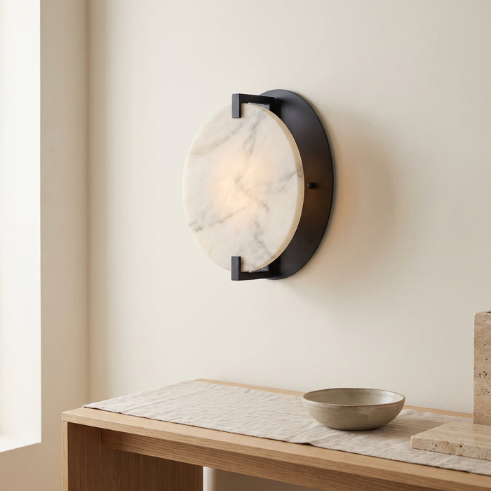 Runde Marmor-Wandleuchte mit warmweißem Licht in einem hellen Flur