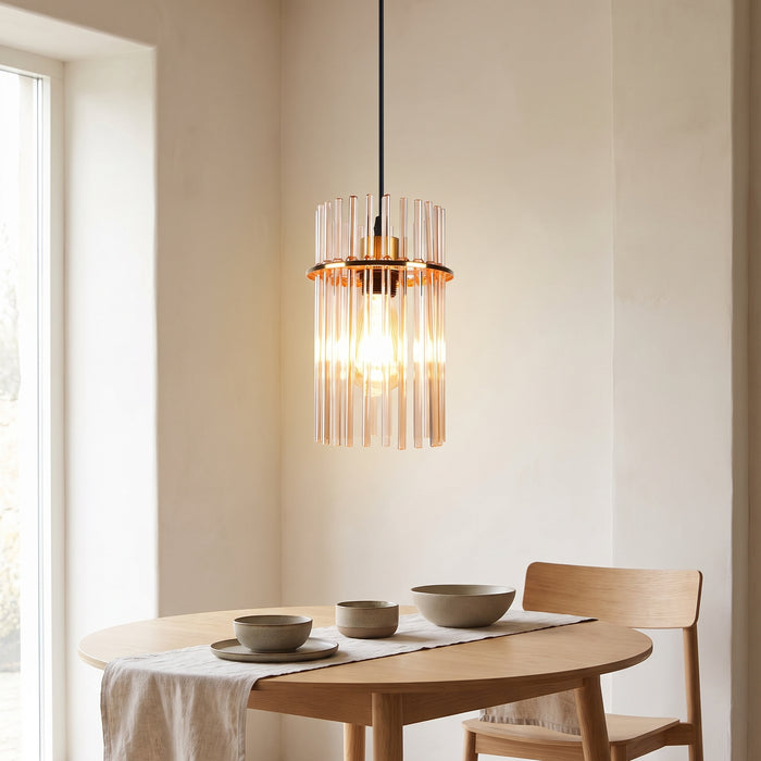 Pendelleuchte mit goldenem Glasstab-Schirm über einem Esstisch in einem hellen Wohnraum