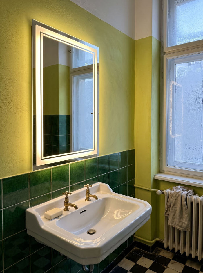 LED-Badspiegel mit Touch-Schalter über einem Porzellanwaschbecken im Altbau-Bad mit grünen Fliesen