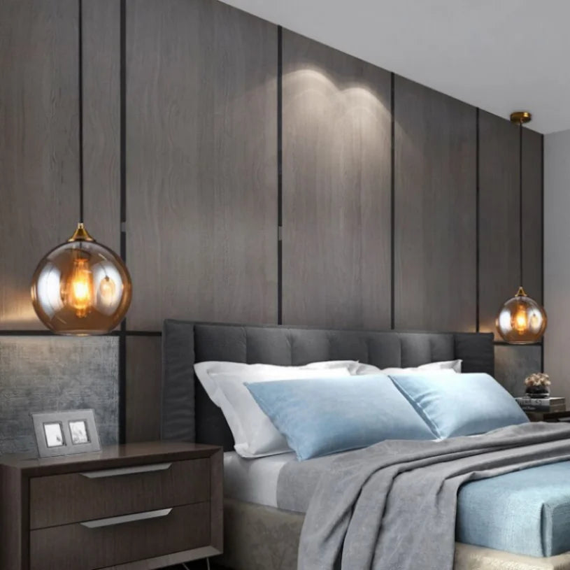 Glas-Pendelleuchten links und rechts neben einem Bett im Schlafzimmer