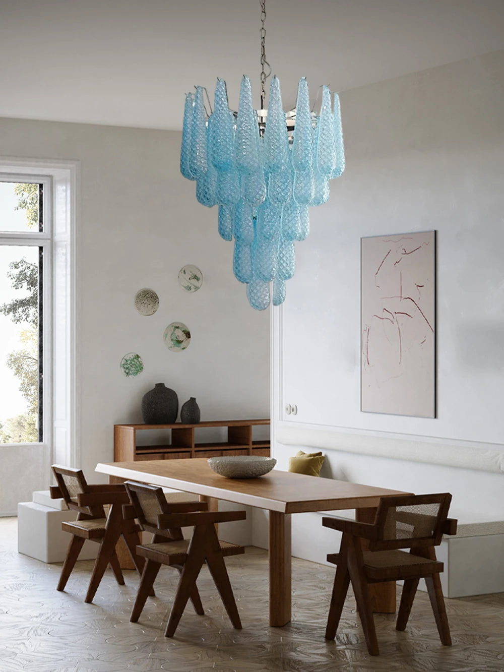 Kronleuchter aus blauem Glas in hellem Esszimmer mit Holztisch