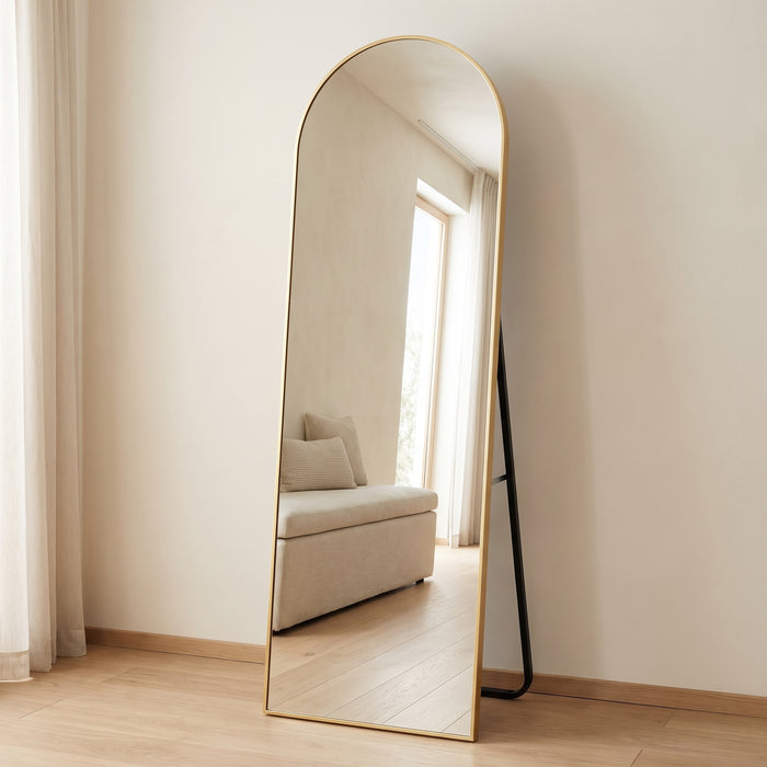 Ganzkörperspiegel in Bogenform mit goldenem Rahmen und Standfuß in einem hellen Schlafzimmer
