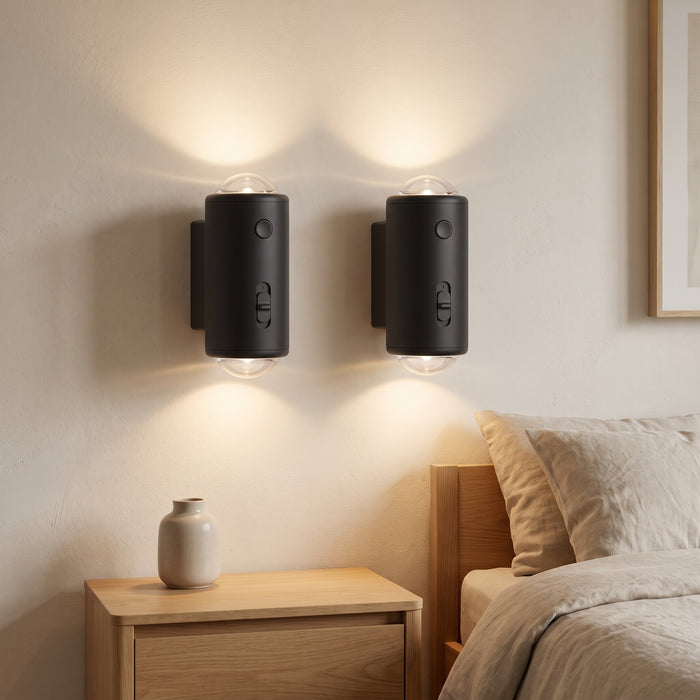 Zwei schwarze LED-Nachtlichter mit Bewegungssensor an der Wand in einem hellen Schlafzimmer