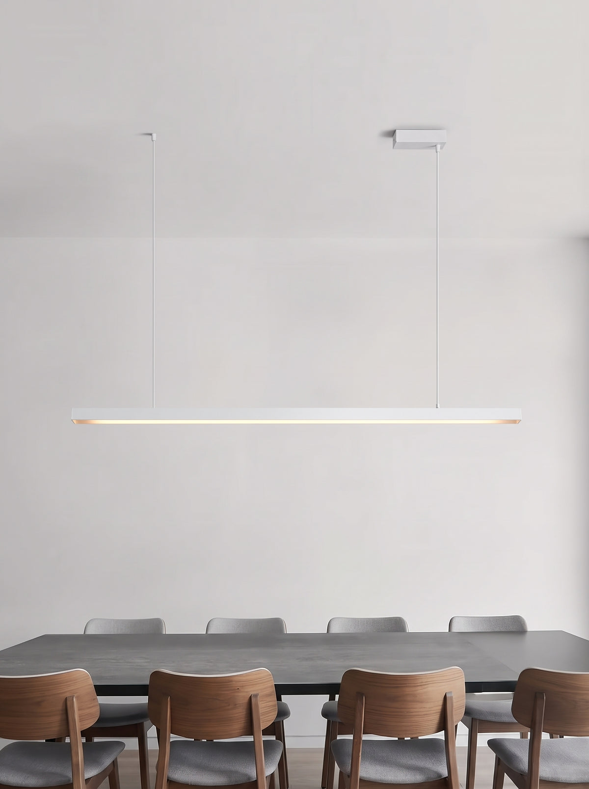 Lineare LED-Pendelleuchte in Weiß über einem Esstisch